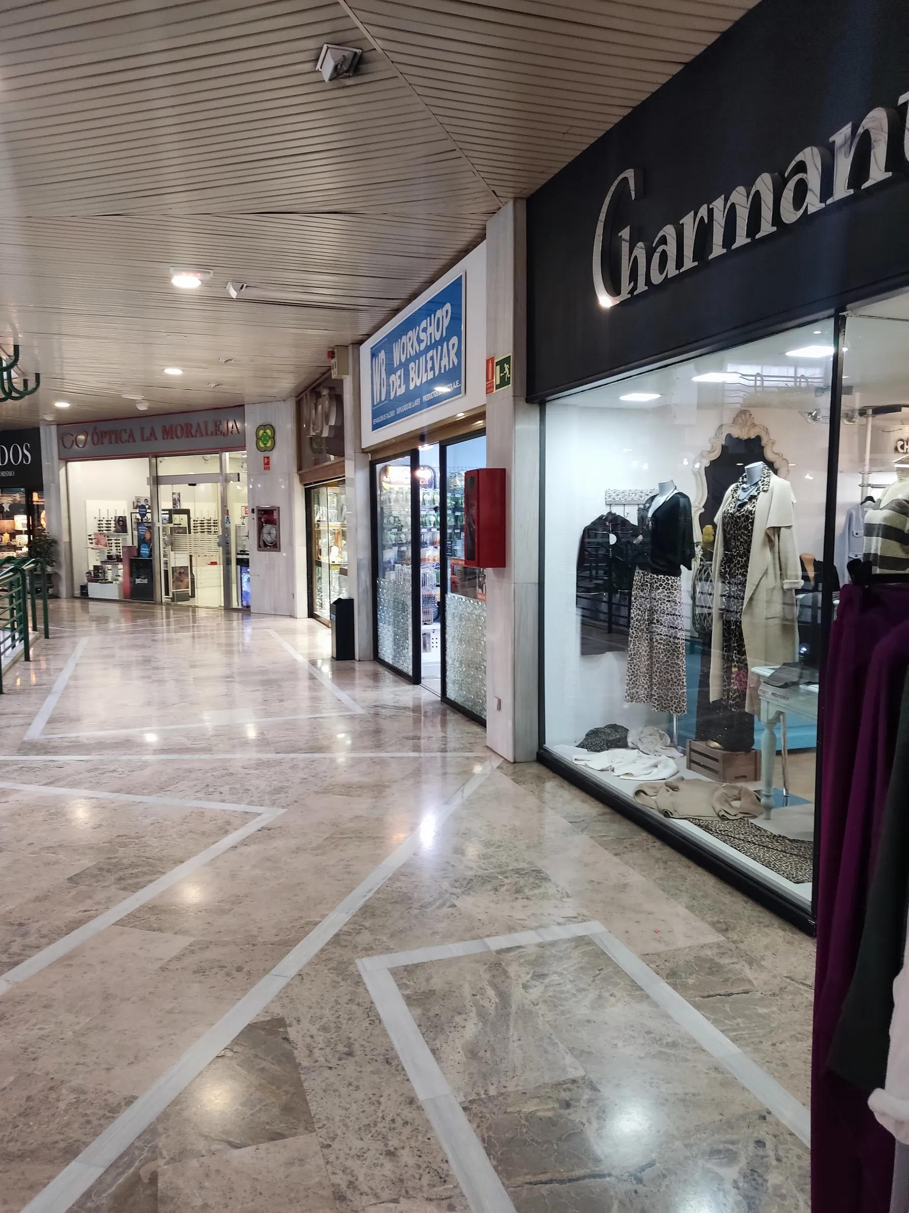 El escaparate de Modas Charmant visto desde el pasillo del centro comercial El Bulevar